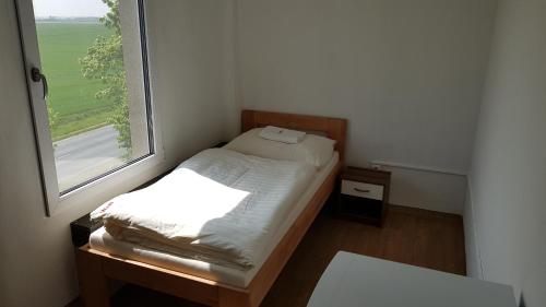 - un petit lit dans une petite chambre avec fenêtre dans l'établissement Country House Reem, à Pommeuse