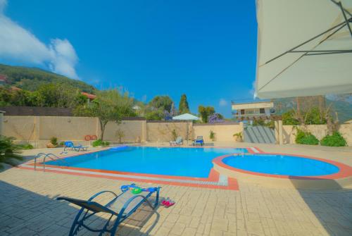 a swimming pool with two chairs next to it at Santalas Villa in Ágios Matthaíos