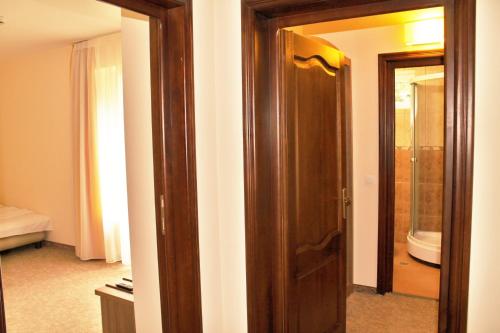 ポイアナ・ブラショフにあるHotel Crisalpinの鏡付きの部屋の木製ドア