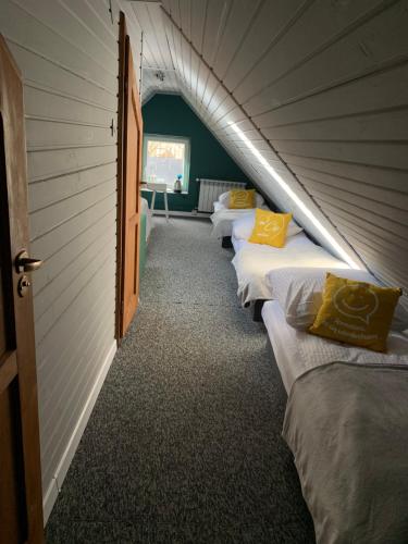 a row of beds lined up in a room at Dworek Zakopane in Zakopane