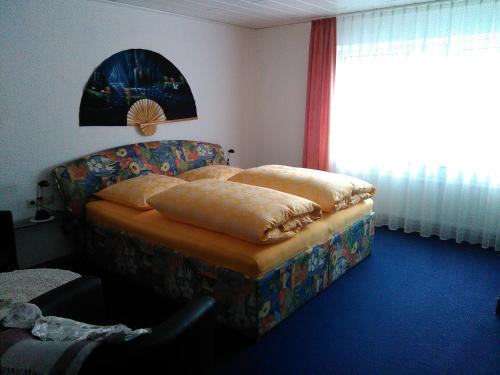 Zimmer mit einem Sofa, einem Stuhl und einem Fenster in der Unterkunft Ferienwohnung Hops in Daisendorf