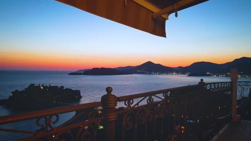 a person standing on a balcony watching the sunset at Villa Edelweiss in Sveti Stefan