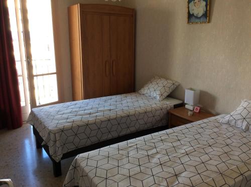 une chambre d'hôtel avec deux lits et une armoire dans l'établissement Le Casone, à Ajaccio