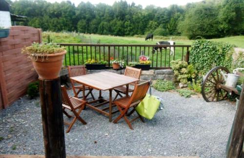 a wooden table and chairs with a table and a fence at Gitavesnois - 4910 - in Willies
