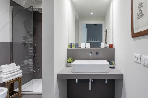 Charming flat Righi Bologna في بولونيا: حمام أبيض مع حوض ودش