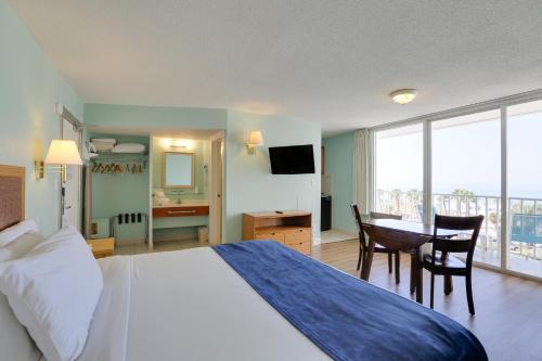 Habitación de hotel con cama, escritorio y mesa. en The Beachview Inn Clearwater Beach, en Clearwater Beach