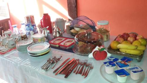 a table with fruit and utensils on it at Toca da Onça in Penedo