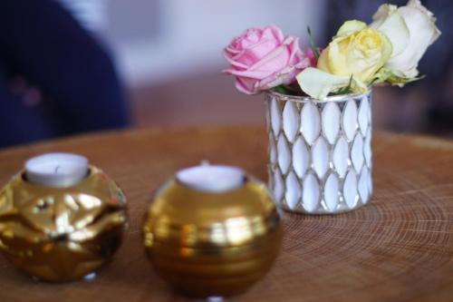 a silver vase with flowers in it next to two candles at Boutique-Hotel Weigels Bergfreiheit in Winterberg