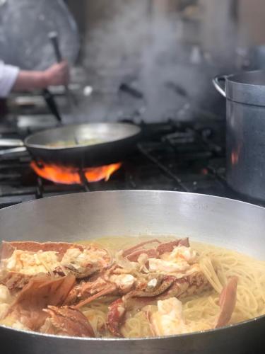 a pan of food with meat and pasta on a stove at Hotel Continental in Vorë