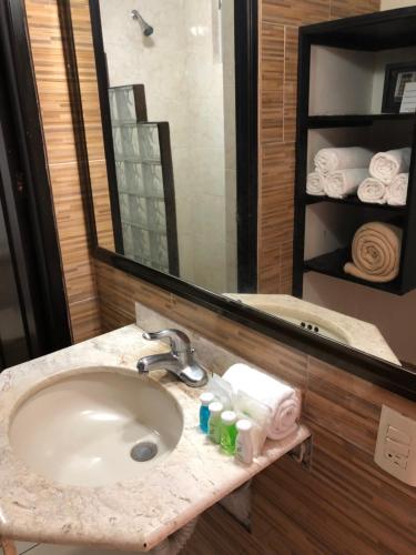 y baño con lavabo y espejo. en VF Villa Florencia Hotel, en Veracruz