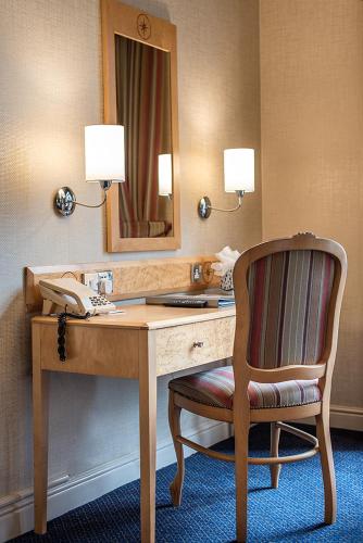a desk with a mirror and a chair in a hotel room at The Parsonage Hotel & Spa in York