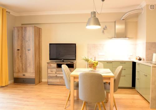 a kitchen and dining room with a table and chairs at Apartamenty Gaja in Krynica Zdrój