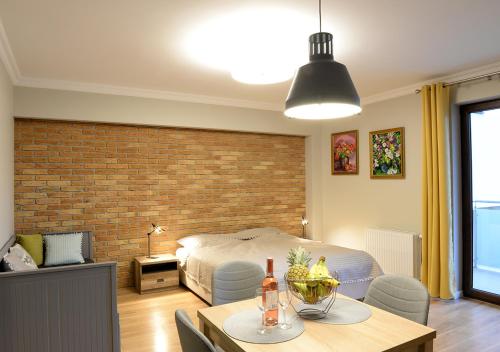 1 dormitorio con cama y pared de ladrillo en Apartamenty Gaja, en Krynica-Zdrój