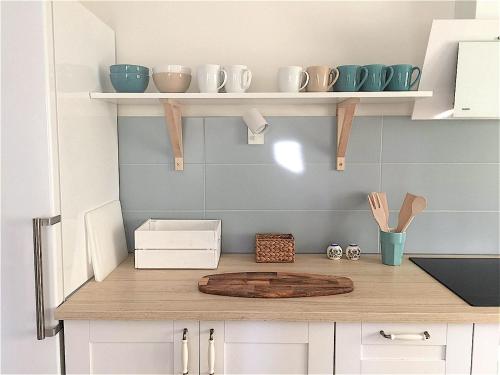 a kitchen with a wooden cutting board on a counter at Marea Apartamenty Ustka in Ustka