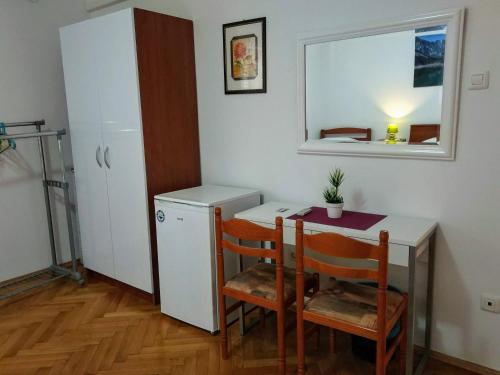 una piccola cucina con un tavolo e un piccolo frigorifero di Zadar Peninsula Accommodation a Zara (Zadar)