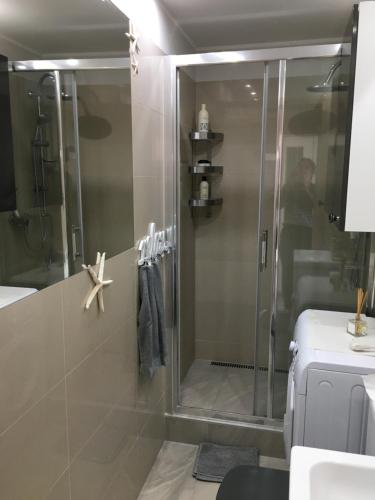 a shower with a glass door in a bathroom at Apartament Armia in Gdynia