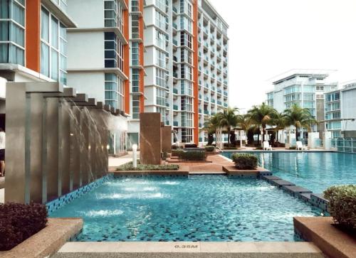 a swimming pool with a fountain in front of some buildings at Ara Damansara Oasis Residence, Specious Home 4-8pax, 8min Subang Airport, 10min Sunway in Petaling Jaya