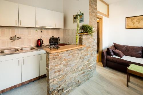 ベオグラードにあるThe Duke Apartmentの白いキャビネットとレンガの壁が備わるキッチン