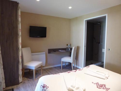 Schlafzimmer mit einem Bett, einem Schreibtisch und einem TV in der Unterkunft Hôtel Kastell Dinec'h in Minihy-Tréguier