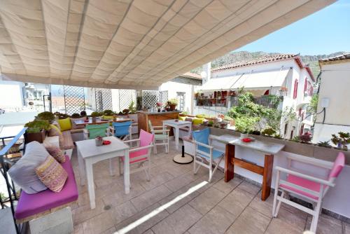a patio with colorful chairs and tables on a roof at Mastoris Mansion in Hydra