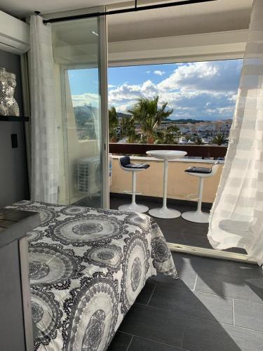 une chambre avec un lit et une vue sur un balcon dans l'établissement Studio DIAMANT naturiste, au Cap d'Agde