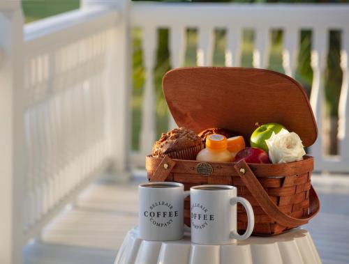 two coffee cups sitting on a table with a basket of produce at Belleview Inn in Belleair