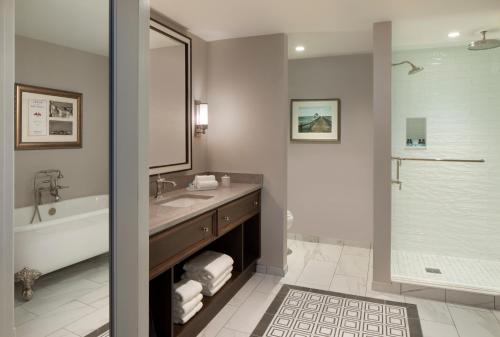 a bathroom with a tub and a sink and a shower at Belleview Inn in Belleair