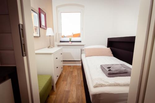 Un dormitorio pequeño con una cama y una ventana. en Ferienwohnung Gründerhaus, en Brandenburg an der Havel