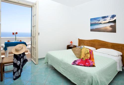a bedroom with a bed and a chair at Hotel Vittorio Beach Resort in Ischia