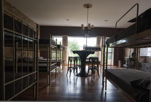 a room with bunk beds and a table and a desk at CASA PELTRE in Sarria