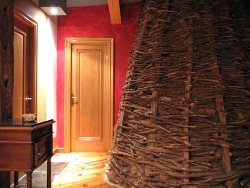 a large stone wall in a room with a door at La Casa del Cura de Calatañazor in Calatañazor