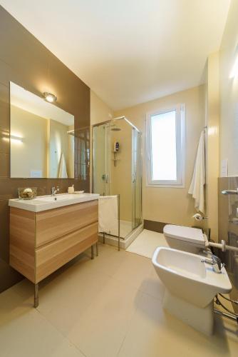a bathroom with a toilet and a sink and a shower at Travini Hotel Residence in Marsala