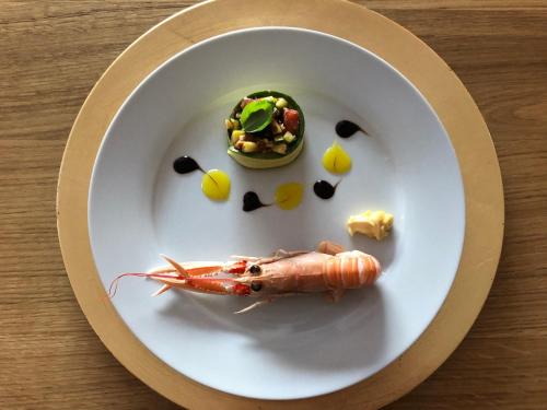 une assiette de nourriture avec une crevette sur une table dans l'établissement Domaine du Clos Pallacien, à Paillé