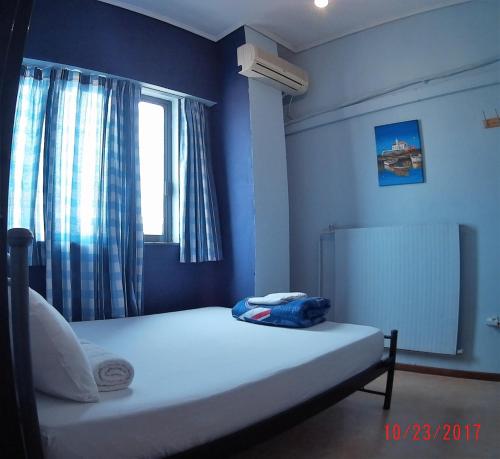 a bed in a blue room with a window at SleepEasy in Athens