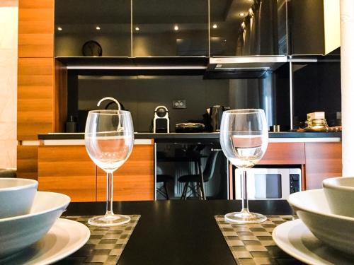 two wine glasses sitting on a table in a kitchen at EPaN Luxury Apartments in Thessaloniki