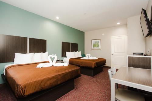 a hotel room with two beds with white towels on them at Express Inn - Spring in Spring