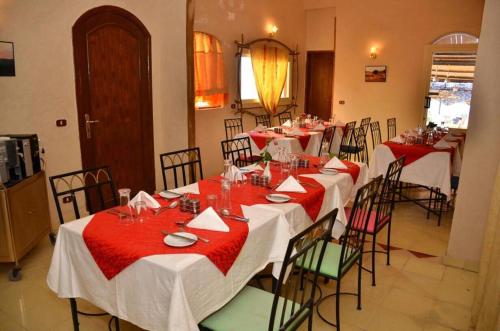 a dining room with long tables with red and white table settings at Dolphin Hotel Safaga in Safaga 