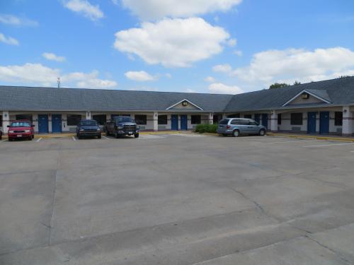 a building with cars parked in a parking lot at Executive Inn & Suites West Columbia in West Columbia
