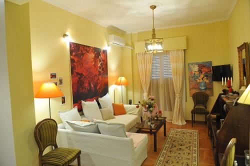 sala de estar con sofá blanco y mesa en Cozy ACROPOLIS, en Atenas