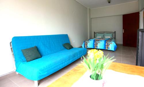 a blue couch in a living room with a table at SleepEasy in Athens