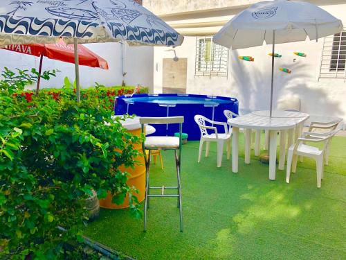 un patio con mesas, sillas y sombrillas en Ótima Localização casa, 7 quartos-Porto de Galinhas 900m piscinas naturais en Porto De Galinhas