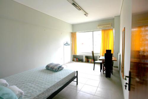 a bedroom with a bed and a desk and a window at SleepEasy in Athens