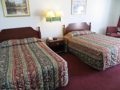 a hotel room with two beds and a table at Executive Inn & Suites West Columbia in West Columbia