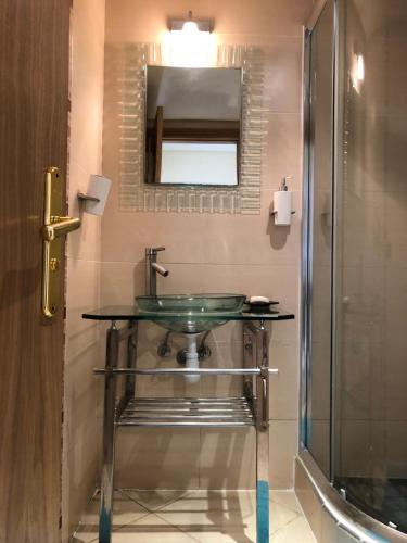 y baño con lavabo de cristal y ducha. en Asilah Marina Golf A3, en Asilah