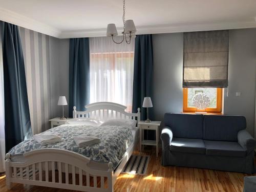 a bedroom with a bed and a couch at Willa 4 Pory Roku & Uznam in Świnoujście