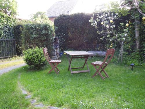 a picnic table and two chairs in the grass at LA DILIGENCE in Jalhay
