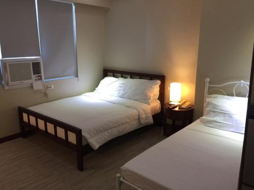 a hotel room with two beds and a window at GOLDEN PEAK CONDO in Cebu City