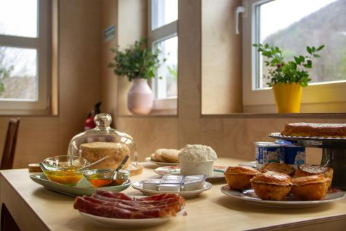 a table topped with different types of bread and pastries at Solar da Castanha - Forest House in Manteigas