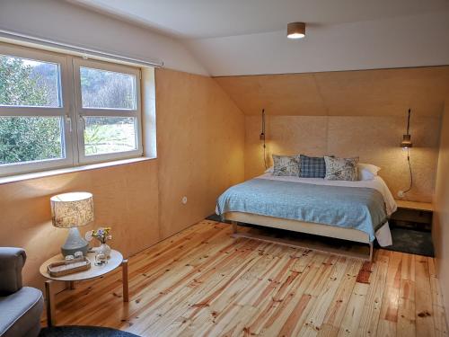1 dormitorio con 1 cama y 2 ventanas en Solar da Castanha - Forest House, en Manteigas