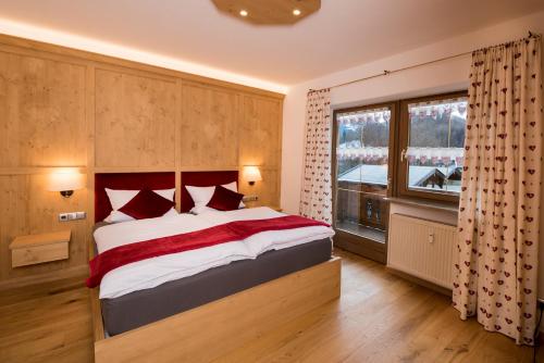 a bedroom with a large bed and a large window at Ferienwohnung Rosenhof in Berchtesgaden